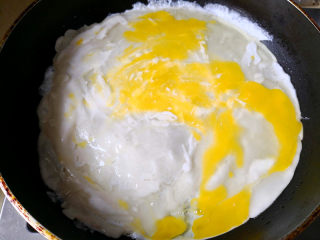 快手早餐之鸡蛋饼,锅里放入适量的油，油热后倒入面糊铺平，面糊成形后，打入鸡蛋，用铲子弄开均匀铺在面饼上，	