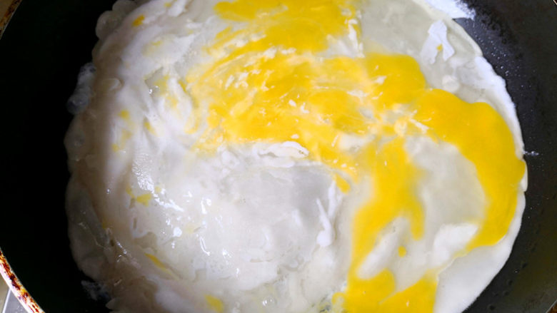 快手早餐之鸡蛋饼,锅里放入适量的油，油热后倒入面糊铺平，面糊成形后，打入<a style='color:red;display:inline-block;' href='/shicai/ 9'>鸡蛋</a>，用铲子弄开均匀铺在面饼上，	