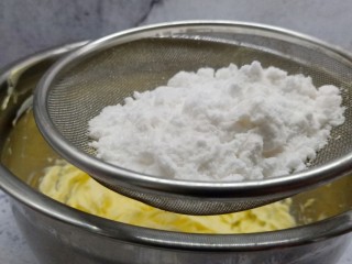 珍妮曲奇花,加糖粉过筛倒入黄油里、搅打均匀。