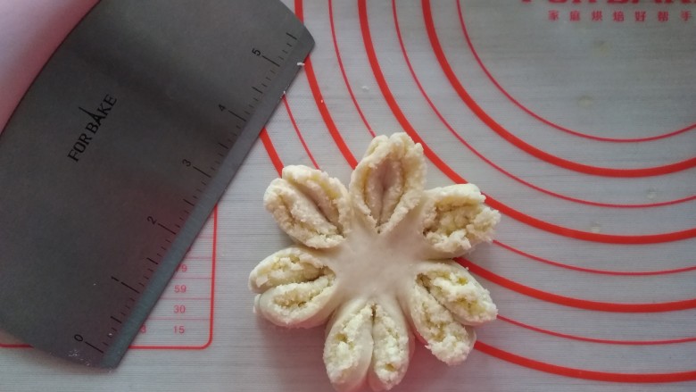 椰蓉花朵面包,每两瓣为一组，右边的向左拧，左边的向右拧，两瓣捏合在一起