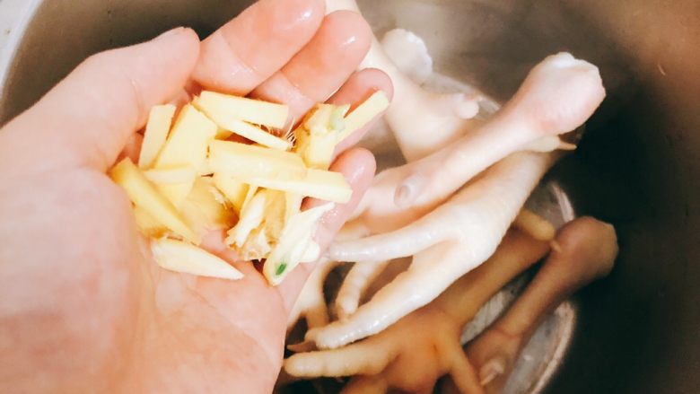 韩式辣鸡爪-下酒、下饭菜,将鸡爪放入高压锅，将蒜切成条一起放入。