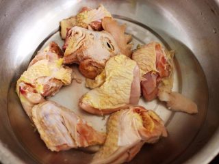 双椒爆鸡块,盆中加入适量清水后，放入5克料酒，把洗净的鸡块放入盆中浸泡一会儿。
