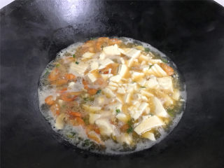 河虾豆腐汤,把盒中的豆腐用锅铲弄成小块后放入锅中一起煮开即可。
