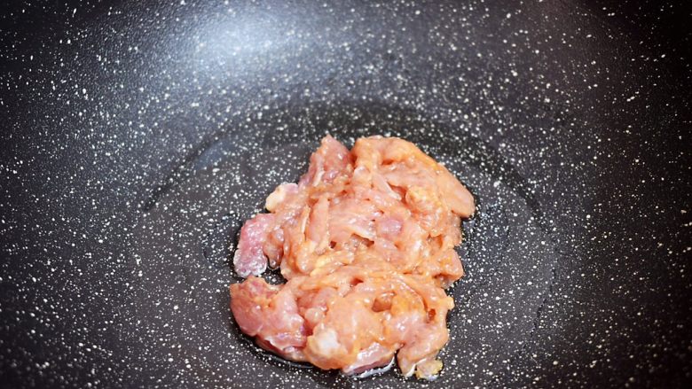 茼蒿炒肉,锅中倒入适量的食用油烧热，放入猪肉