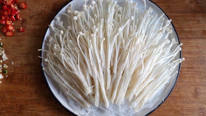蒜蓉粉丝蒸金针菇——快手下饭就靠它,将洗净的金针菇切根，撕开铺在粉丝上。