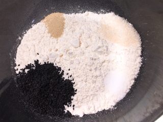 松软芝麻包,高筋粉中分别加入盐、细砂糖、芝麻、发酵粉。