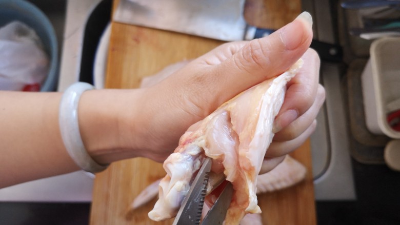 奥尔良鸡翅包饭,用剪刀✂️将连着中间骨头的筋剪断。