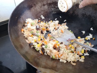 奥尔良鸡翅包饭,饭炒好后快要起锅时，撒入胡椒粉再翻炒一下就可以装盘了。
