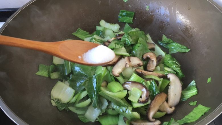 香菇炒油菜,放入少许的盐，翻炒均匀。