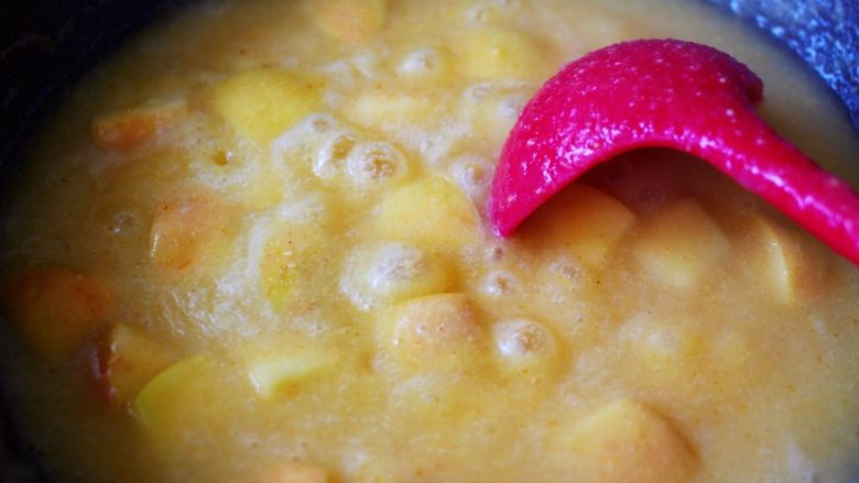 百变水果  玉米面百合苹果粥,小火继续慢慢熬制、直至苹果块熬制的断生变色的时候。