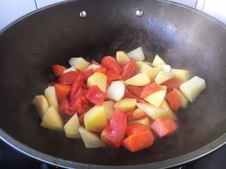 番茄土豆烧牛肉,另外起锅，热锅凉油，放入土豆、胡萝卜、番茄块（另外一部分的）。