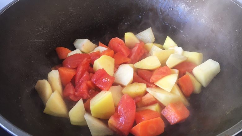 番茄土豆烧牛肉,另外起锅，热锅凉油，放入土豆、胡萝卜、番茄块（另外一部分的）。