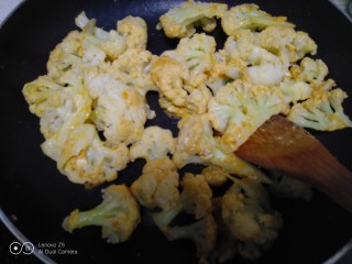 黄金炒菜花,倒入菜花，快速翻炒，使菜花上均匀粘上咸蛋黄。