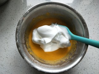 南瓜戚风蛋糕,先将打好的蛋白取三分之一放入蛋黄糊中翻拌均匀