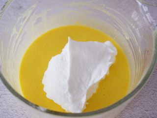 斑马纹戚风蛋糕,把三分之一的蛋白霜加入蛋黄糊中，翻拌或都上下拌匀