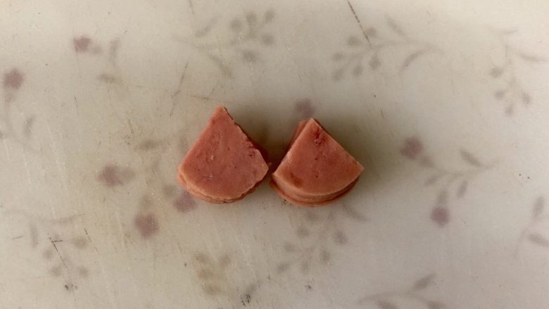 黄金小猪馒头片,正圆的火腿片，切成如图的小扇形，做小猪的耳朵。