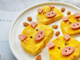 黄金小猪馒头片,用海苔剪出小猪的表情，放在相应的位置，完成。