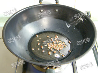 金针酸汤肥牛,炒锅内放入一大匙油，冷油放入花椒用小火炸至出香味，捞出花椒。