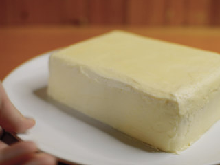 红丝绒蛋糕 无需酪乳 奶酪霜抹面,四边都挤上奶酪霜，裱花嘴怼着蛋糕，奶酪就比较服帖。
然后用小刀和刮板，慢慢抹面，把蛋糕抹成一块豆腐。
奶酪霜质地紧实，室温26度以下不容易软化，用来练习抹面再合适不过了。