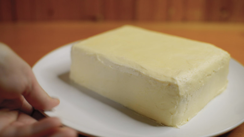 红丝绒蛋糕 无需酪乳 奶酪霜抹面,四边都挤上奶酪霜，裱花嘴怼着蛋糕，奶酪就比较服帖。
然后用小刀和刮板，慢慢抹面，把蛋糕抹成一块豆腐。
奶酪霜质地紧实，室温26度以下不容易软化，用来练习抹面再合适不过了。