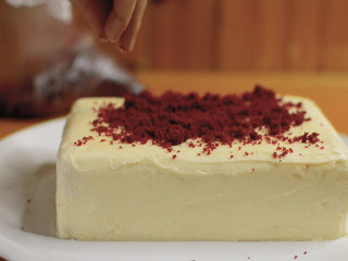 红丝绒蛋糕 无需酪乳 奶酪霜抹面,蛋糕的边角料不要丢，放进保鲜袋，捏一捏，撒在蛋糕上，制造奢华的红丝绒视觉效果。