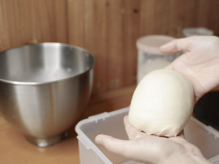 绵绵脆巧奶油包,加入黄油揉到面团光滑。
从机器中取出，双手打湿防粘。
将面团拢成圆形。