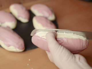 绵绵脆巧奶油包,成功的巧克力淋面用刀敲上去是硬硬的，手摸一下不会融化，也不会留下指纹。面包对半切开。