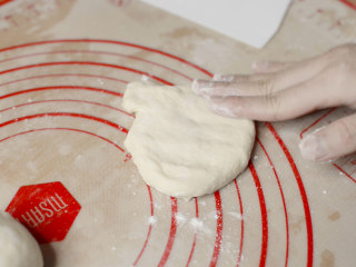 绵绵脆巧奶油包,接着来滚圆面团。
在分好的面团上撒一点点面粉防粘。拍扁。