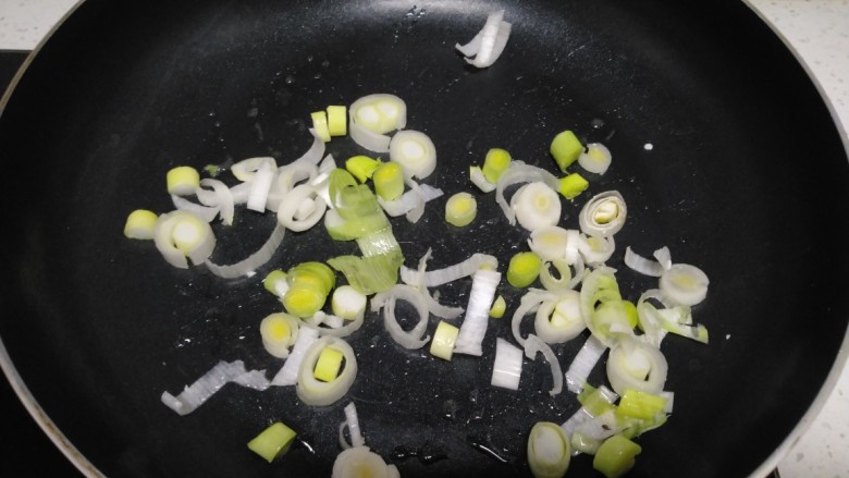 咸蛋清南瓜菜焖方便面,不粘锅中放入少量油，炒香葱、蒜苗根碎。