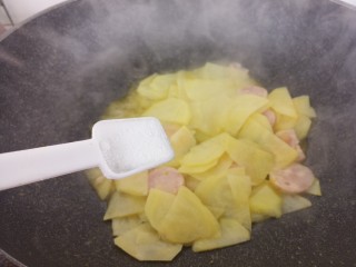 土豆片炒香肠,然后加一勺盐。