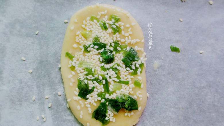 葱花油酥饼,擀成方形，刷上一层蛋液，撒上白芝麻和葱花