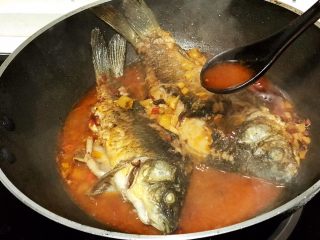 浅湘食光&干烧鲫鱼,用小勺不断将汤汁浇在鱼上，为鱼更入味
