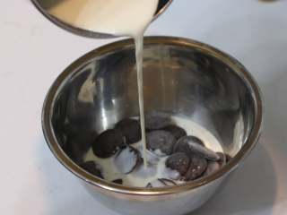 巧克力熔岩杯子蛋糕,	淡奶油煮沸后冲入巧克力中（淡奶油一旦沸腾，气泡会非常剧烈。所以一但沸腾就要马上离火。不然容易溢出）
