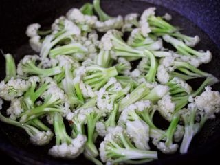 辣爆菜花海虾,菜花用手撕成小块状，锅中倒入适量的清水烧开后，放入一勺盐后把菜花进行焯水备用。