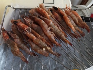 孜然烤虾,虾串在签子上，放到烤架上