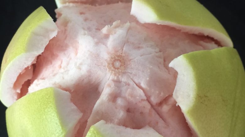 清火润肺蜂蜜柚子酱,用刀尖插入柚子皮，深度约1cm左右，从顶部到底部将柚子皮分割成6～8块，然后剥下外皮； 