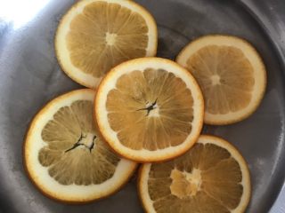 橙子蛋糕卷,把橙子片放进炖锅中倒入180g水和30g的糖中火熬到橙子皮变透明就可以关火