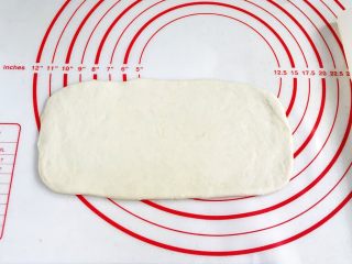 贝果汉堡包,用擀面杖擀成20×10cm大小的方形面片。