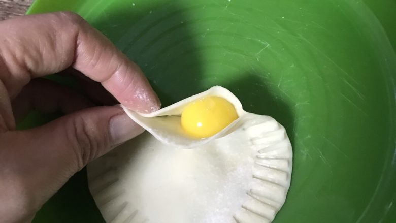 灌蛋饺子皮,把鹌鹑蛋从留出的口子灌入饺子皮并捏紧