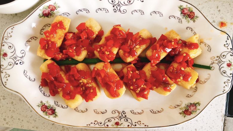 鞭炮迎春-年夜饭,将炒好的剁椒酱铺在每一个豆腐条上。