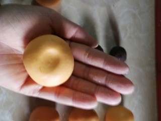 南瓜糯米糍,光滑的面朝上，食指指尖在中心压一下。