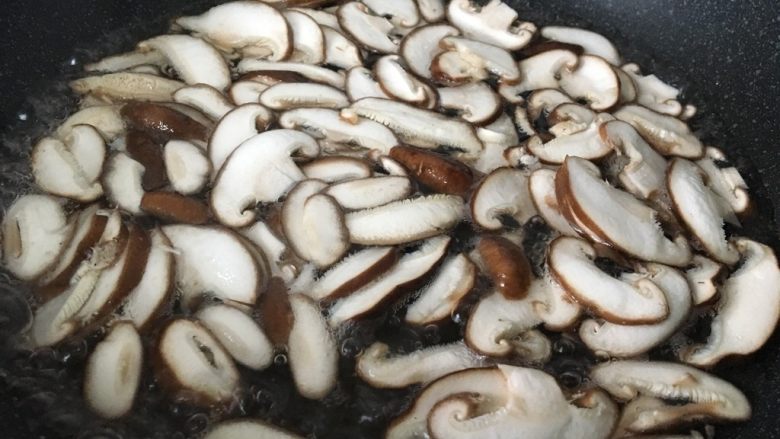 香菇炒鸡蛋,锅中加水和1克盐烧开，把香菇片焯水。
