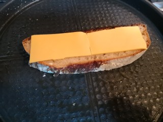 电饼铛版快手三明治,电饼铛上铺一块面包片，铺上一片奶酪。