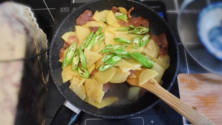 香肠土豆片盖浇饭,打开锅盖，收汁。待汁水快收干时，加入青椒，并加入适量的盐，翻炒均匀。