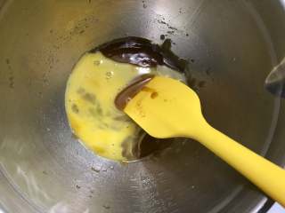 巧克力软曲奇,等黄油混合液冷却后加入鸡蛋液，搅拌均匀。
