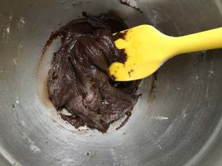 巧克力软曲奇,将可可粉、低筋面粉、小苏打混合过筛加入黄油中，用刮刀搅拌均匀。