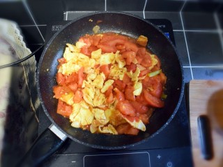 西兰花番茄炒鸡蛋盖浇饭,番茄变软后，倒入鸡蛋，用铲子将鸡蛋饼捣成小块。