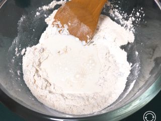 蔓越梅黄油面包,翻拌均匀后倒入牛奶再翻拌至面粉结团。