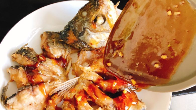 油炸糖醋版孔雀开屏鱼-年夜饭、宴请菜类,将汤汁浇在鱼身上。