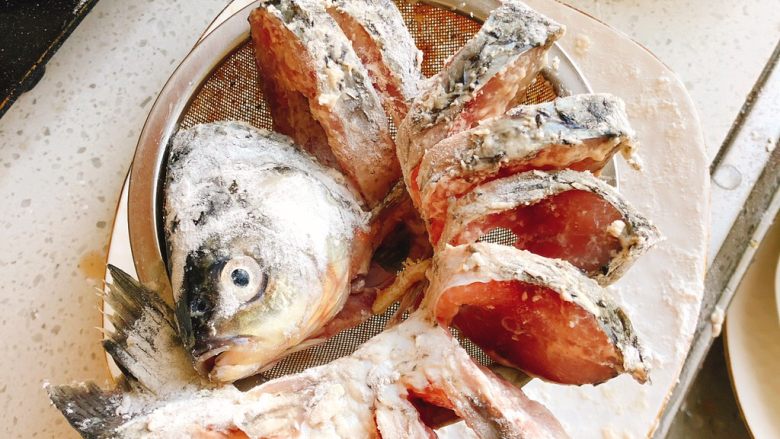 油炸糖醋版孔雀开屏鱼-年夜饭、宴请菜类,取一个干燥的漏勺，把鱼展开装在漏勺里，以防鱼下锅炸时鱼肉粘连在一起，也能更好定型。